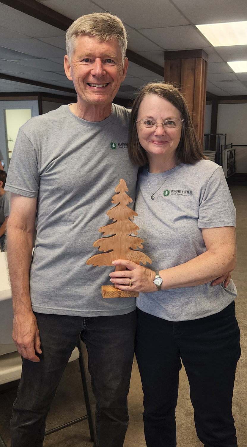 Bob O'Neill Jr. and his wife, Loretta, hold a tree carving created by Lewis County Work Opportunities.